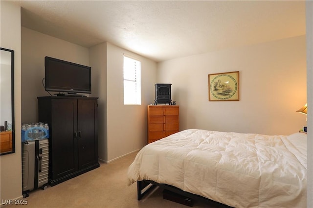 bedroom featuring baseboards and light carpet