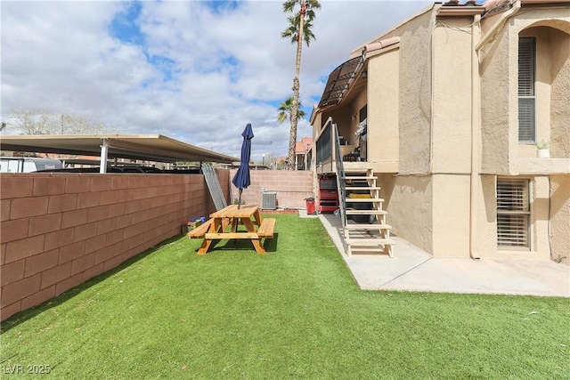 view of yard with a patio area, stairway, and a fenced backyard