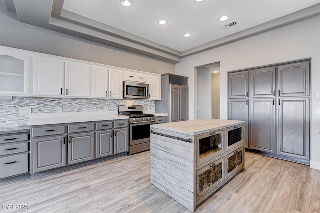 kitchen with visible vents, gray cabinets, stainless steel appliances, light countertops, and white cabinetry