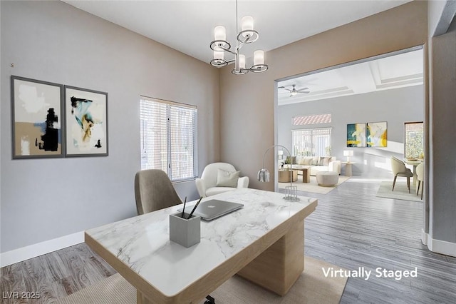 office space with ceiling fan with notable chandelier, wood finished floors, and baseboards