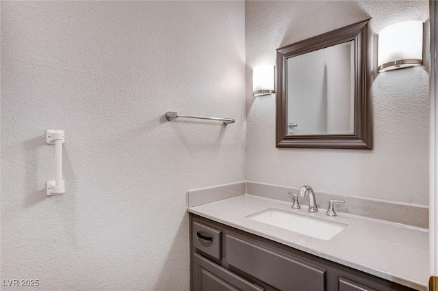 bathroom featuring vanity and a textured wall