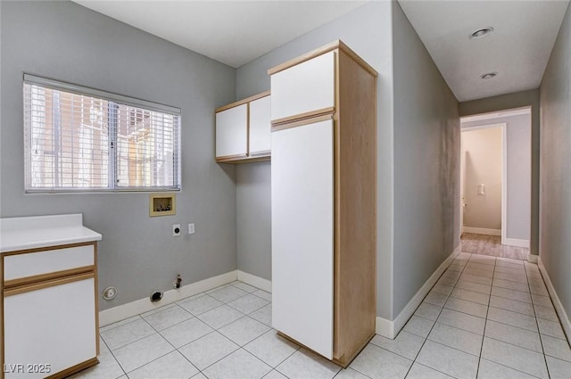 clothes washing area featuring light tile patterned floors, hookup for a gas dryer, hookup for an electric dryer, and hookup for a washing machine