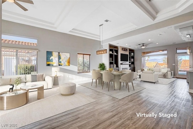 dining space featuring a ceiling fan, beam ceiling, wood finished floors, and visible vents