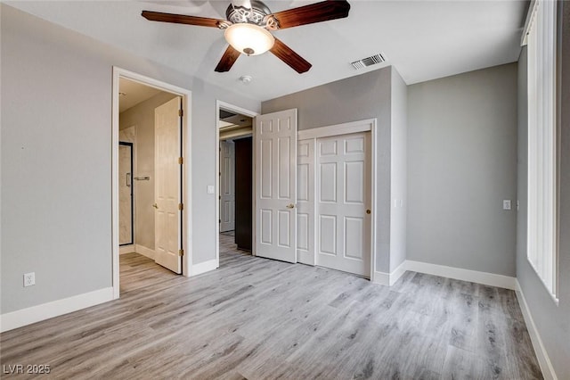 unfurnished bedroom featuring visible vents, baseboards, light wood-style floors, and a closet