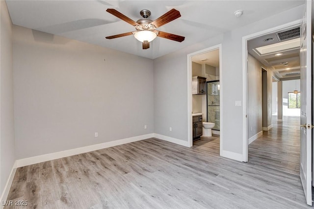 unfurnished bedroom featuring ensuite bath, ceiling fan, baseboards, and light wood-style floors