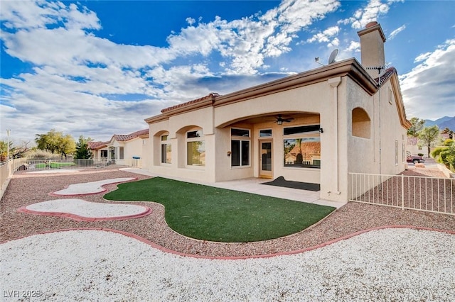 back of house with stucco siding, ceiling fan, a patio, and fence