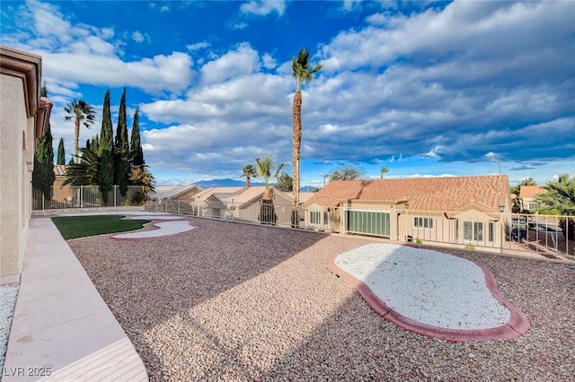 view of yard featuring a gate, fence, and a residential view