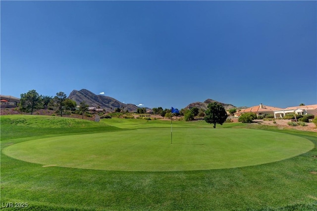 view of property's community featuring a mountain view, a lawn, and golf course view