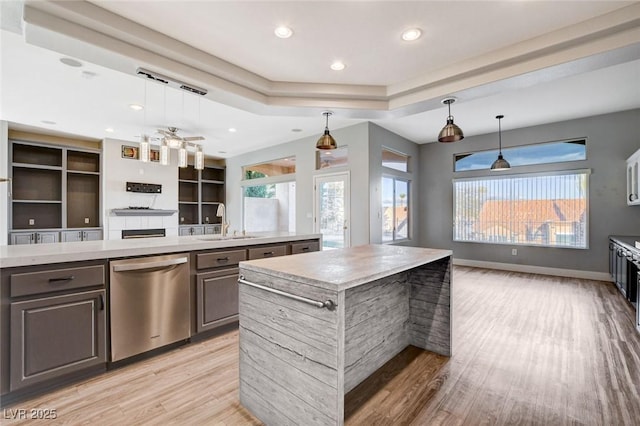 kitchen with a sink, a kitchen island, dishwasher, and open floor plan