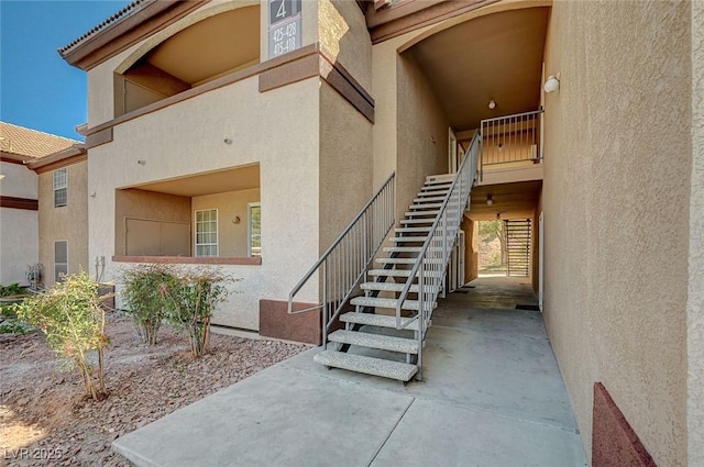 exterior space featuring stucco siding and a tiled roof