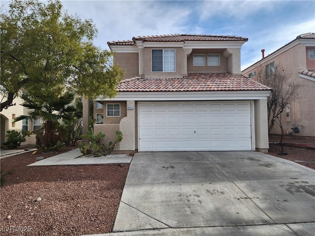 mediterranean / spanish home with concrete driveway, a tiled roof, an attached garage, and stucco siding