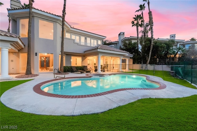 2221 Glenbrook Way, Las Vegas, NV 89117 - pool at dusk featuring a patio area, fence, a pool with connected hot tub, and a lawn