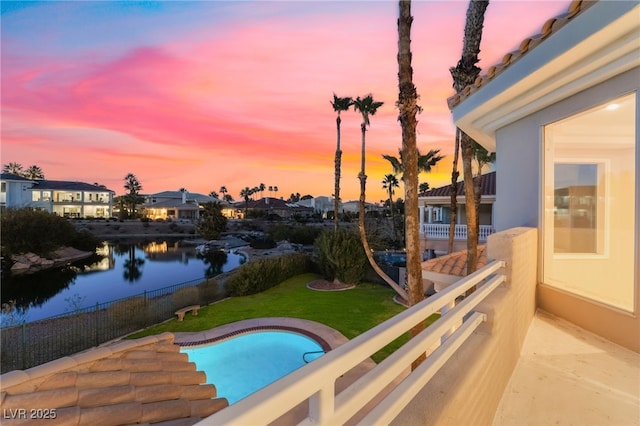 2221 Glenbrook Way, Las Vegas, NV 89117 - pool at dusk with a fenced in pool, fence, a yard, and a water view