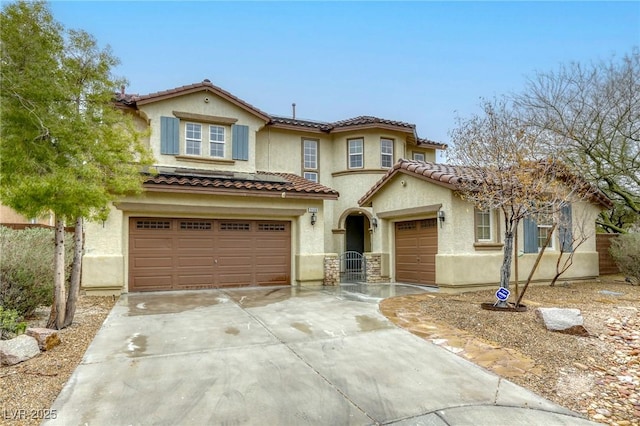 mediterranean / spanish-style house featuring stucco siding, concrete driveway, an attached garage, and a tiled roof