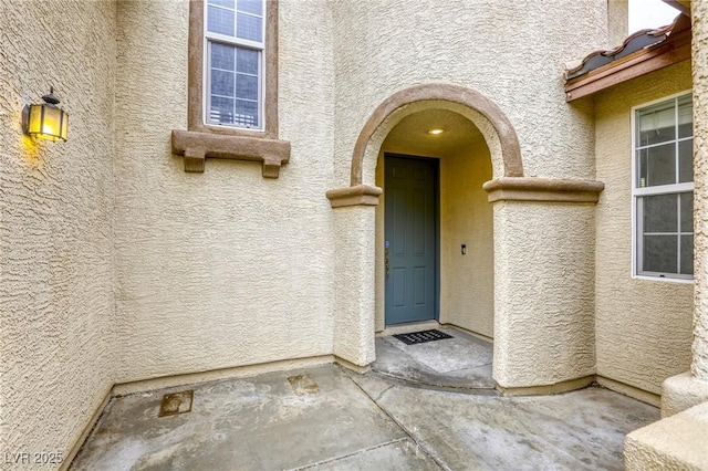 view of exterior entry with stucco siding