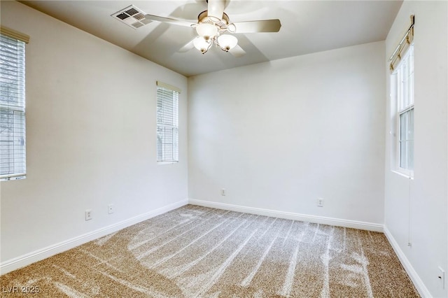 spare room with carpet flooring, baseboards, visible vents, and ceiling fan