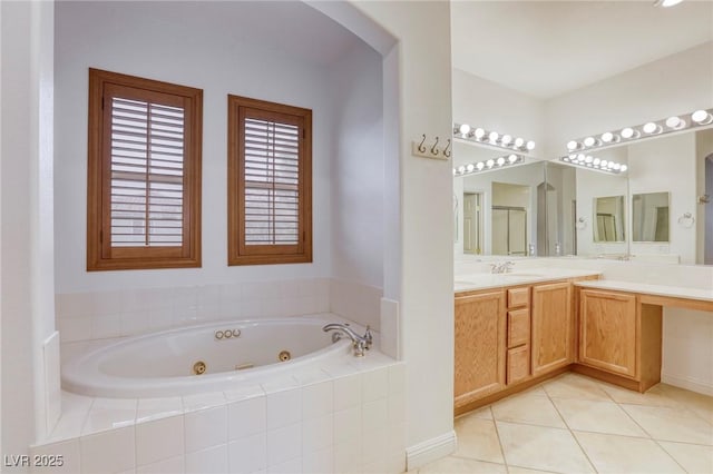 bathroom with a jetted tub, vanity, and tile patterned flooring