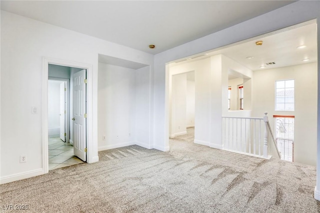 carpeted empty room with tile patterned flooring and baseboards
