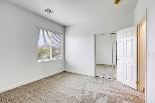 unfurnished bedroom with visible vents, carpet, baseboards, and a closet