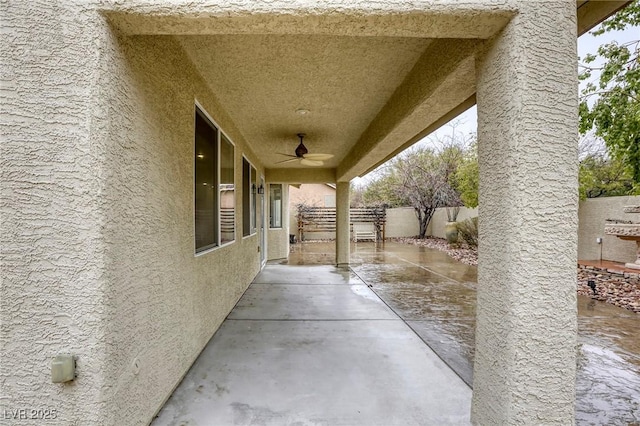 view of patio featuring a ceiling fan and fence