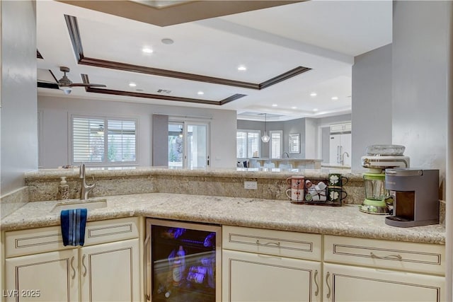 kitchen featuring beverage cooler, ornamental molding, a wealth of natural light, and a sink