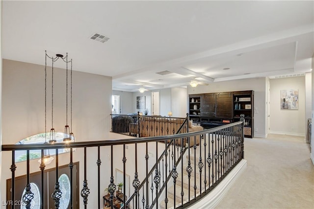 corridor with visible vents, an upstairs landing, light colored carpet, and baseboards