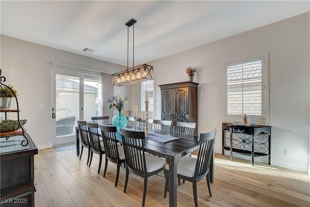 dining room featuring light wood-type flooring, baseboards, and visible vents