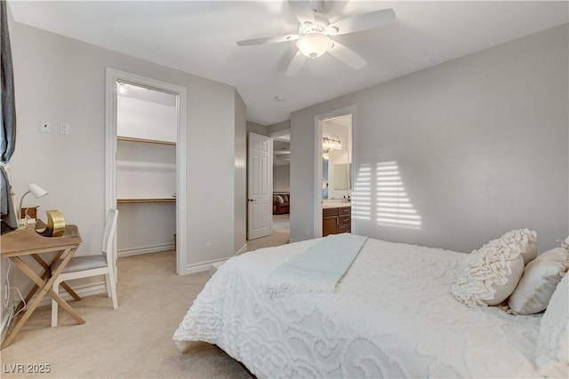 bedroom featuring a closet, baseboards, light colored carpet, ceiling fan, and a spacious closet