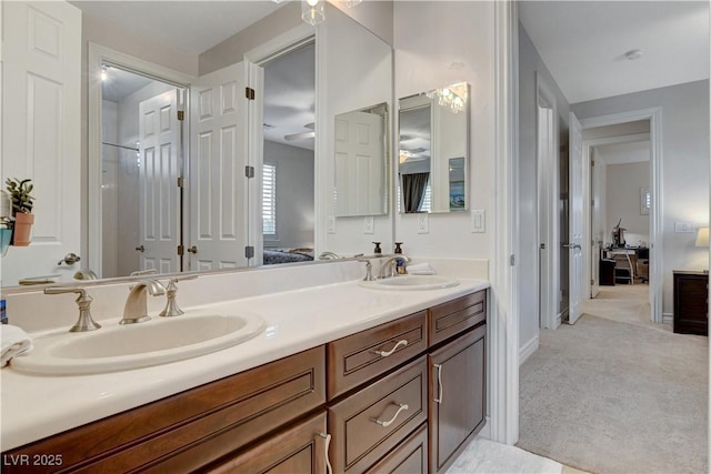 ensuite bathroom featuring a sink, connected bathroom, and double vanity