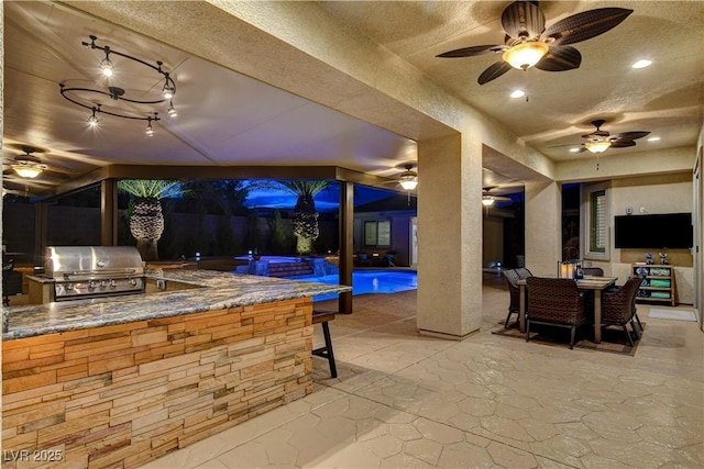 view of patio / terrace with outdoor dining space, exterior kitchen, a fenced in pool, and a grill