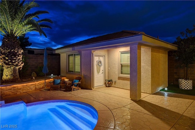 exterior space featuring stucco siding, fence, and a patio area