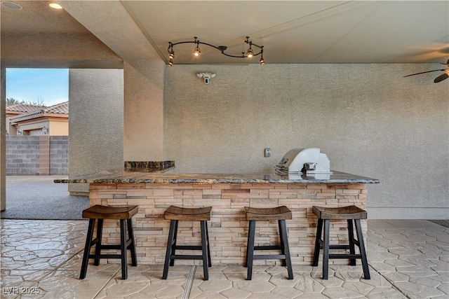 view of patio with outdoor wet bar and a ceiling fan