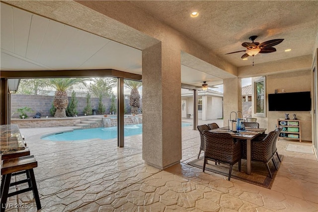 view of pool with outdoor dining space, a fenced backyard, a pool with connected hot tub, ceiling fan, and a patio area