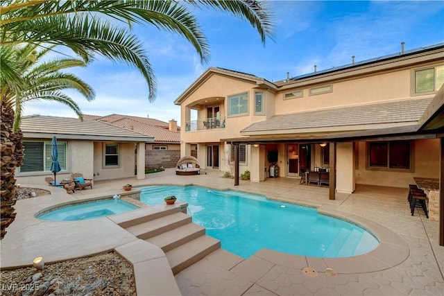 outdoor pool featuring an in ground hot tub, a patio, and fence