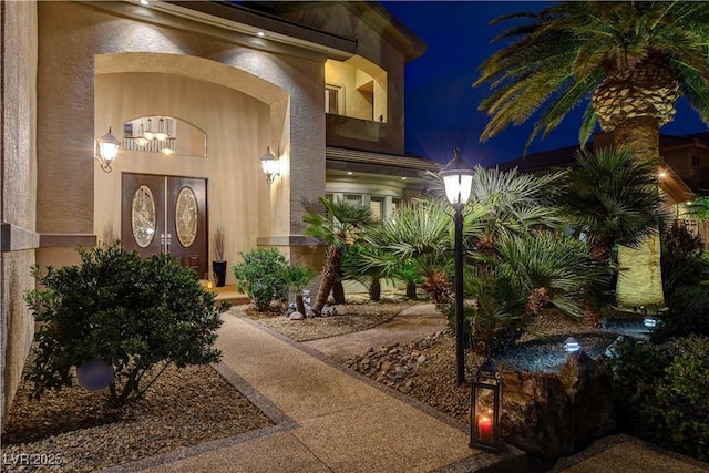 exterior entry at night with stucco siding