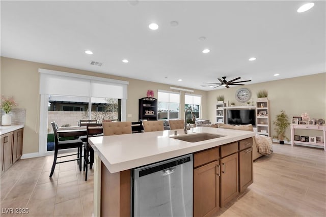 kitchen with visible vents, open floor plan, dishwasher, an island with sink, and a sink