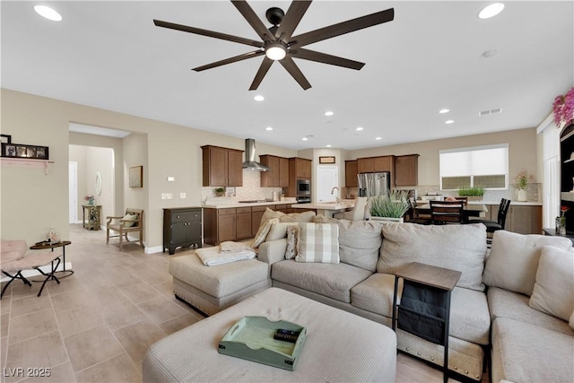 living room with a ceiling fan, recessed lighting, visible vents, and baseboards