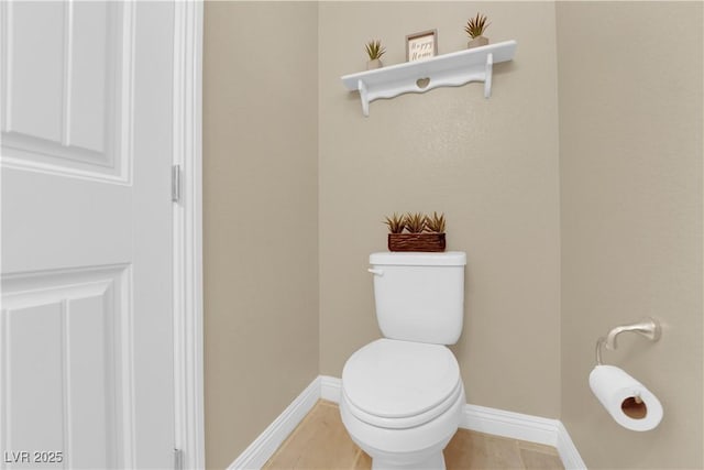 bathroom with toilet and baseboards