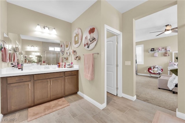 full bathroom featuring baseboards, vanity, ceiling fan, and ensuite bathroom