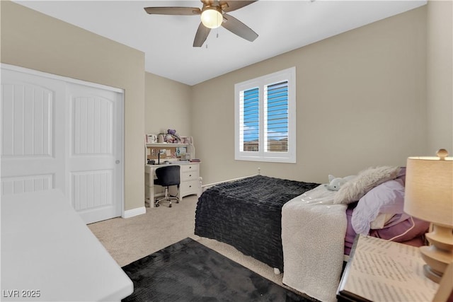 carpeted bedroom featuring a closet, baseboards, and a ceiling fan