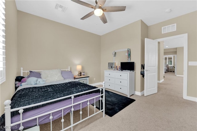 carpeted bedroom with visible vents, baseboards, and ceiling fan