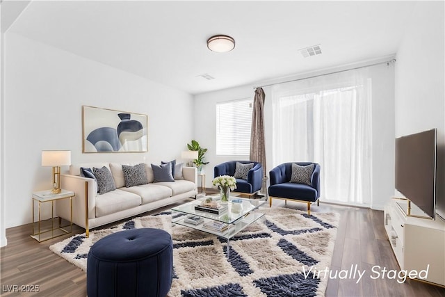 living area featuring wood finished floors and visible vents