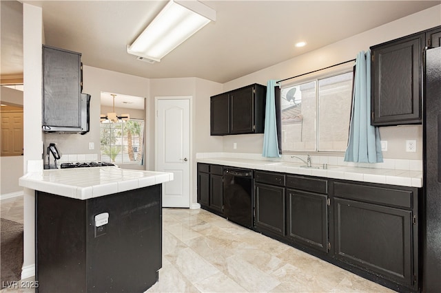 kitchen with visible vents, a sink, dark cabinetry, dishwasher, and tile counters