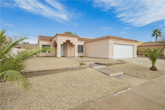 mediterranean / spanish house with fence, an attached garage, stucco siding, concrete driveway, and a tiled roof