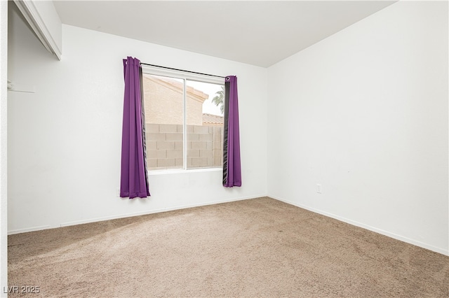 empty room with baseboards and carpet