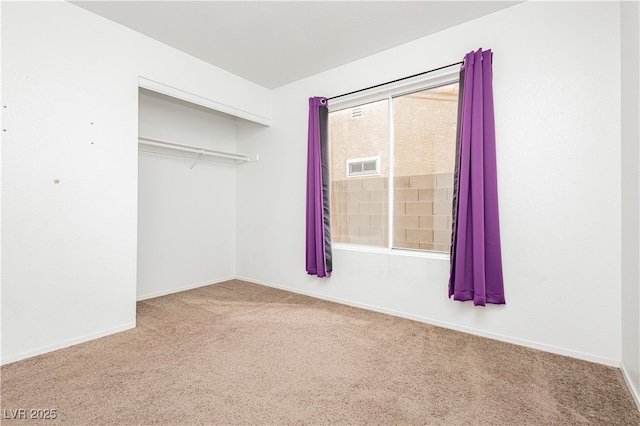 unfurnished bedroom with a closet, visible vents, carpet flooring, and baseboards