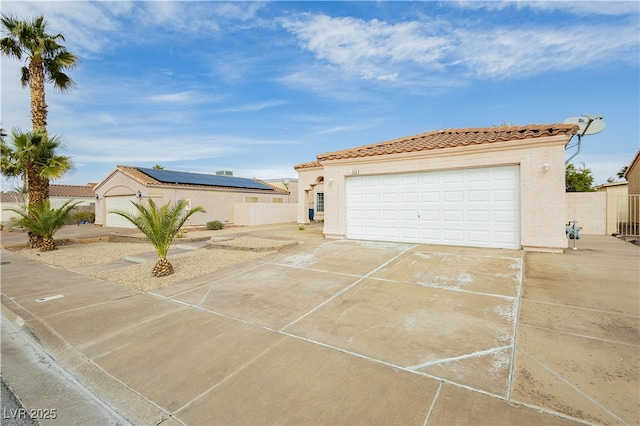 garage featuring driveway and fence