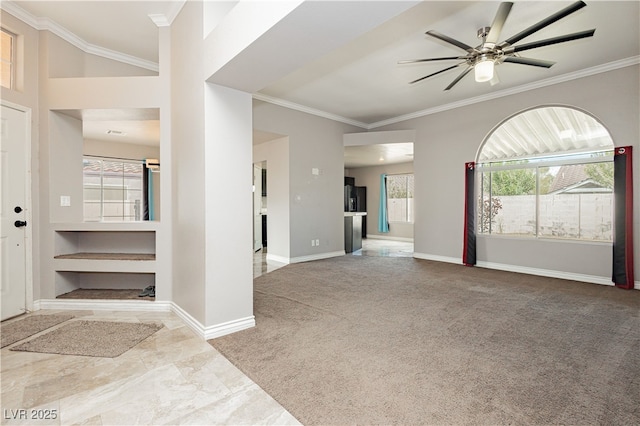 foyer with baseboards, carpet, ceiling fan, and crown molding