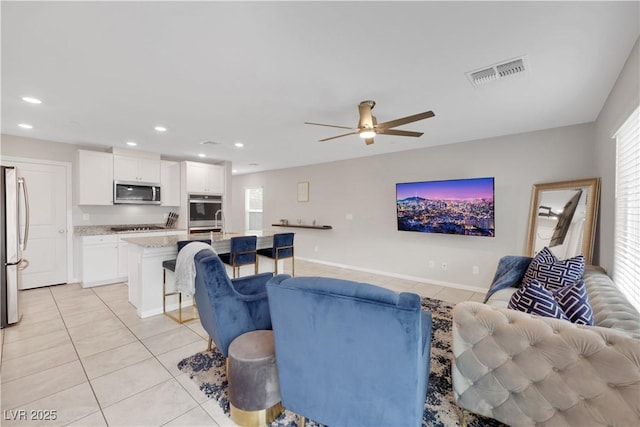 living room featuring light tile patterned floors, visible vents, recessed lighting, and a wealth of natural light