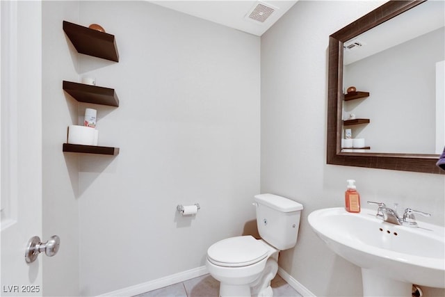 bathroom featuring tile patterned floors, visible vents, toilet, a sink, and baseboards